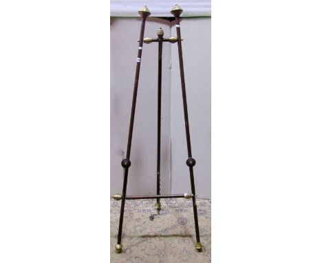 A floorstanding A framed folding artists easel, with simple turned wooden frame and brass finials