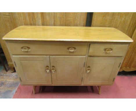 1956 Ercol 351 light elm and beech sideboard, enclosed by three rectangular panelled doors beneath two frieze drawers, with d