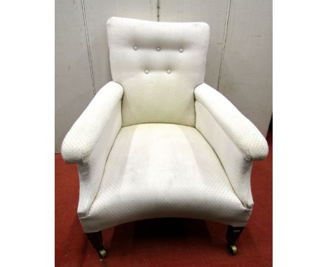 A late 19th century low armchair, with upholstered finish, button back, concave seat, shaped outline and square tapered forel