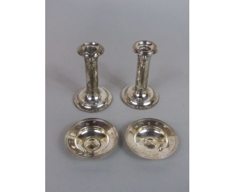 Two small silver alms type dishes, 3oz approx, together with a further pair of silver candlestick (4)