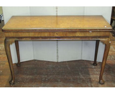 A Georgian side or serving table principally in walnut, the crossbanded top in quarter veneered elm, raised on four pad feet 