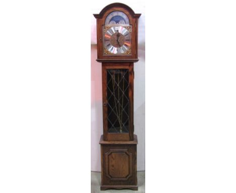 A contemporary reproduction grandmother/longcase clock, the case enclosed by a leaded panel door, beneath an arched hood and 