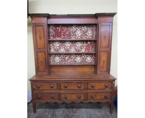 A Georgian oak countrymade dresser, the lower section enclosed by six short drawers, the raised plate rack fitted with three 