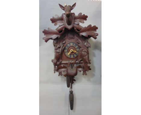 Black Forest cuckoo wall clock, the case carved with a stag head, boxing hare and game bird, the ebonised chapter ring painte