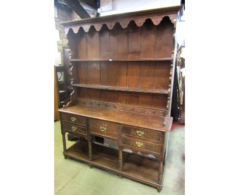 A Georgian oak cottage dresser, the lower section enclosed by an arrangement of five drawers over an open pot board with turn