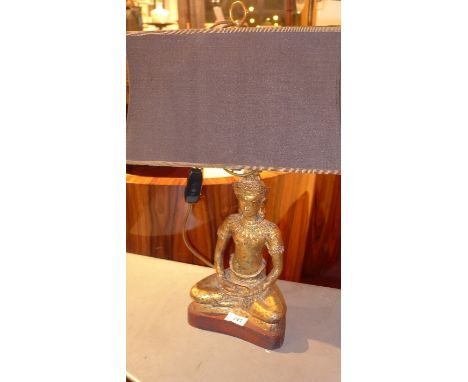 A gilt heightened table lamp in the form of a seated Buddha, H:60cm