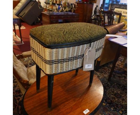 A vintage wicker work box/stool, raised on ebonised legs. 
