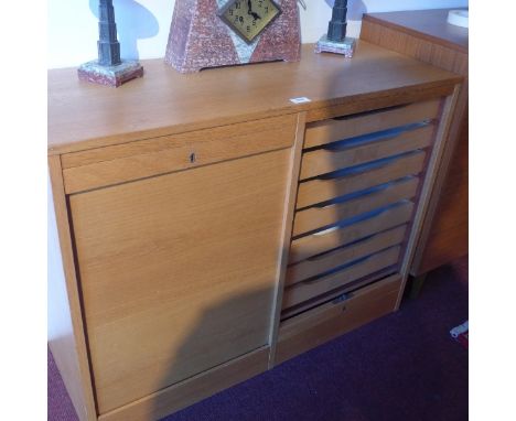 A 20th Century light oak side cabinet having two sliding tambour doors enclosing drawers, H:76cm W;98cm D:38cm