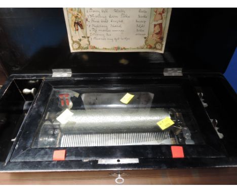 A late 19th Century music box, in simulated rosewood and ebonised case, playing 8 airs, hand written label, numbered 28944