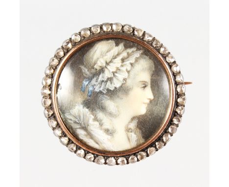 A SMALL DIAMOND AND GOLD FRAMED CIRCULAR PORTRAIT BROOCH  of a lady wearing a bonnet. 2.5cms diameter.