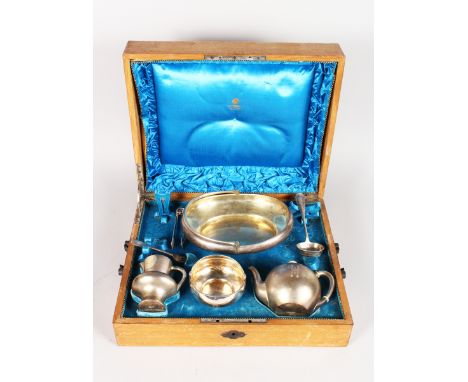 A COMPOSITE SET OF RUSSIAN SILVER, in an oak canteen comprising oval basket with swivel handle, globular teapot, circular sug