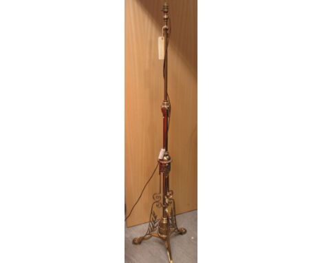 An early 20th century brass standard lamp on paw feet  
