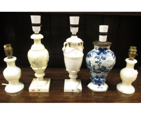 A collection of five alabaster and a Delft table lamp  