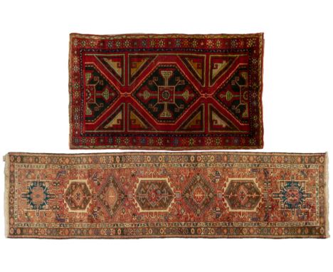 A muted red ground North West Persian Karadja runner with a typical geometric device on a field of stylised motifs within flo