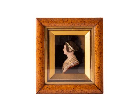 A 19th century miniature relief portrait in wax of Queen Victoria, facing left, glazed in a walnut frame, handwritten text ve