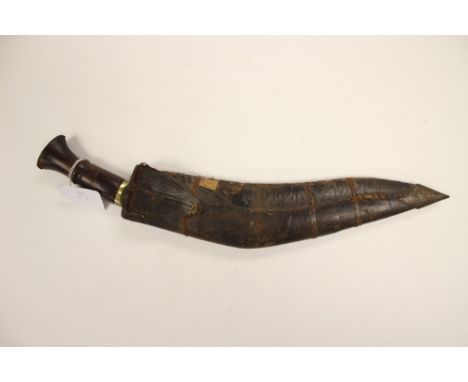 Gurhka Kukri knife with woodens grip and brass furniture. 32cm plain steel blade. No markings. Complete with scabbard. Missin