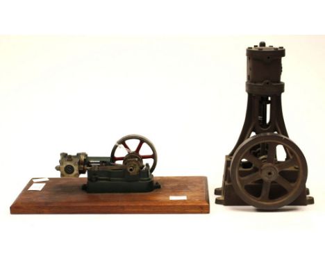 Stuart-Turner: A miniature stationary engine on a wooden base together with a vertical piston and flywheel.