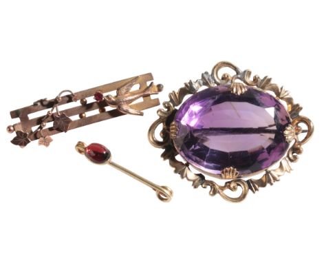 AN AMETHYST BROOCH the oval brilliant cut stone approx 3cm x 2.5cm x 1.5cm deep, in gold coloured metal pierced leaf mount, 4