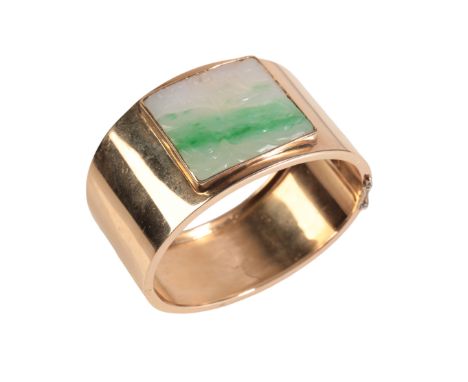 A 14K GOLD AND JADE SET CUFF BANGLE the pierced face carved with trees, plain hinged body, 6.5cm wide, gross weight 39gProven