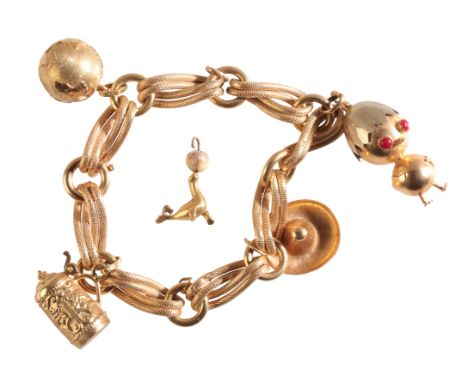 A YELLOW METAL CHARM BRACELET hung with various 18ct stamped charms and other carats of gold, charms to include globe, seal, 