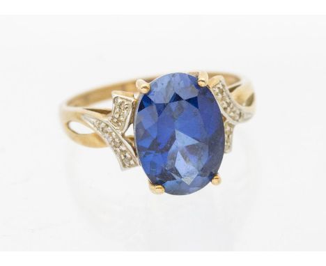 A synthetic sapphire and diamond 9ct dress ring, claw set oval and sapphire,  approx 13 x 9mm, to cross over diamond set shou