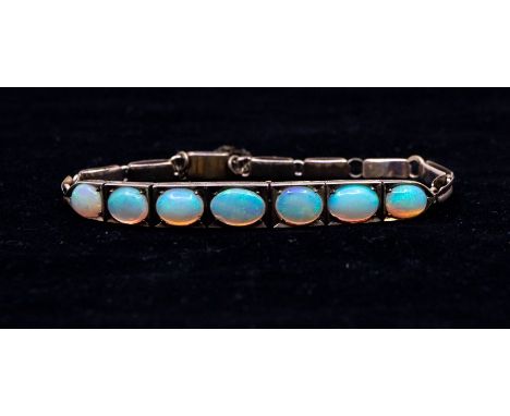 An early 20th century opal and 9ct gold bracelet, the top set with seven  graduated oval opals, to a fancy link bracelet with