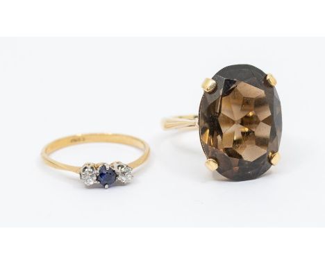 A small sapphire and diamond three stone 9ct gold dress ring, size O, along with a large smoky quartz and 9ct gold ring, size