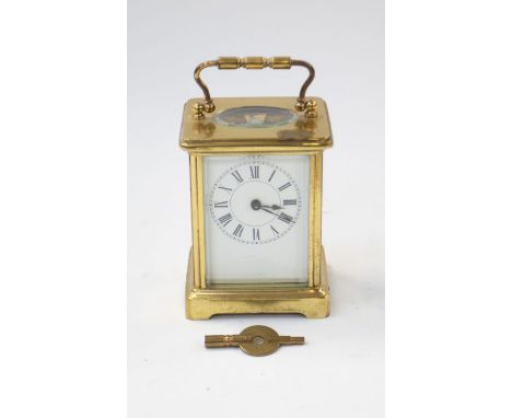 A 20th Century brass cased small carriage clock, handle to top, French movement, maker to front behind glass worn away so unr