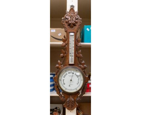 A 20th century Reynolds &amp; Sons of London carved oak barometer with leaf design. Approx. 88cm long.
