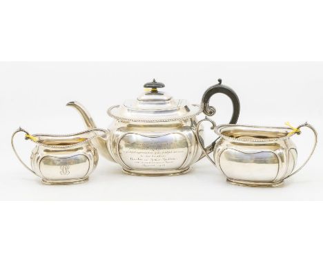 A George V silver three piece tea service comprising teapot, sugar bowl and milk jug, gadroon borders above lobed bodies, ebo