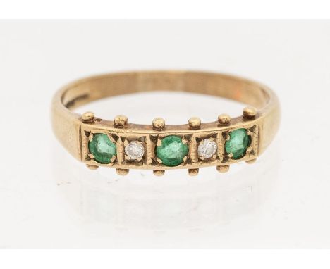 An emerald and diamond 9ct gold ring, comprising three round mixed cut emeralds and two small brilliant cut diamonds, beaded 