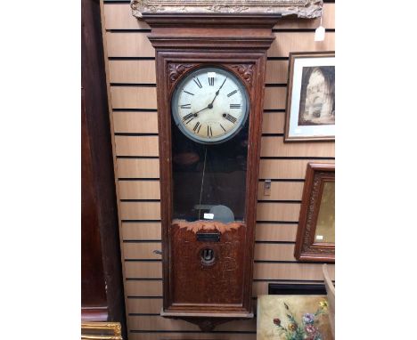 A Bland wall clocking in clock or Industrial Time Recorder. Contained in an oak case. With markings on the dial and inside th