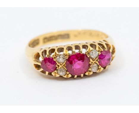 An early 20th century ruby and diamond 18ct gold ring, round mixed cut rubies with small diamond accents, claw set, width app