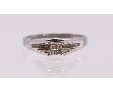 A diamond and 14ct white gold ring, comprising four princess cut diamonds set to tension/ claw setting, total diamond weight 