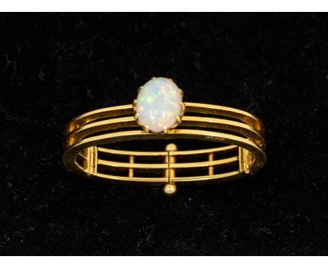 An opal and 18ct gold early 20th century scarf clip comprising a hinged form of three gold bars overlaid with an oval opal, t