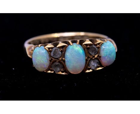 An Edwardian opal and diamond 18ct gold ring, comprising three graduated oval opals with small diamond set accents, width app