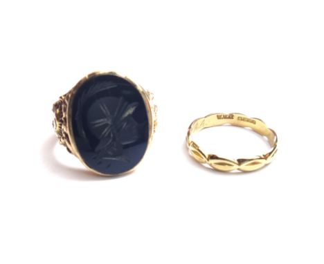 A gold and black onyx set intaglio ring, carved as a classical portrait, the mount with cast decoration, ring size S and a ha