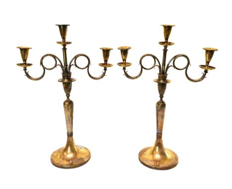 A pair of European silver three light table candelabra, each with scrolling arms and on a circular trumpet shaped base, heigh