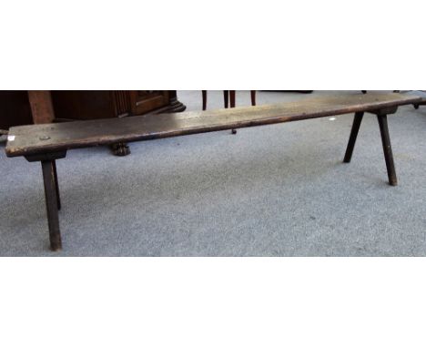 A 19th century oak rectangular bench on four staked supports, 184cm wide. 