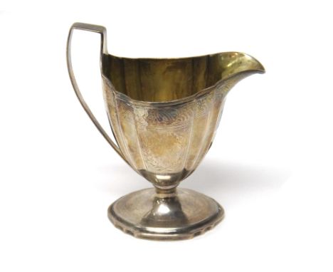 A Scottish silver milk jug, of panelled helmet shaped form, with engraved decoration and with an angular handle, Edinburgh pr
