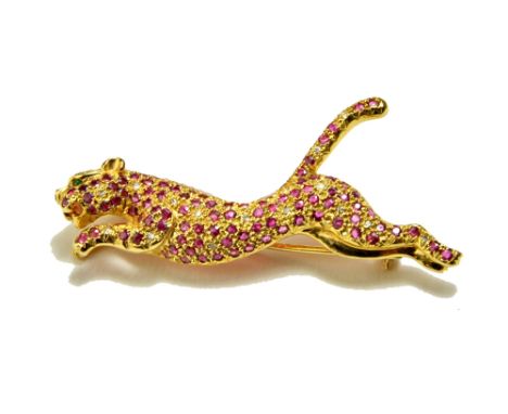 A gold, ruby and diamond set brooch, designed as a leaping leopard, having an emerald set eye, detailed 585 14K and a gold, r