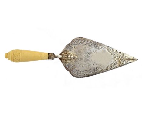 A Victorian silver model of a masonary trowel, with pierced and engraved decoration and having a carved ivory handle, (the pr