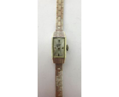 A lady's 9ct white gold Rotary bracelet wristwatch, with a signed rectangular silvered dial, on a three tier brick link brace