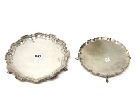 A silver salver of shaped circular form, having a piecrust rim, in the Chippendale style and raised on three scrolling feet, 