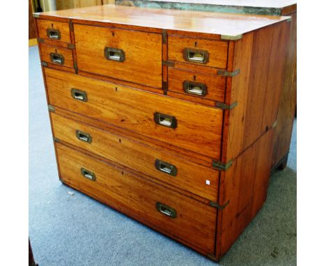 A 19th century teak two part campaign chest on five short over three long drawers, on screw off bun feet with retailers disc 