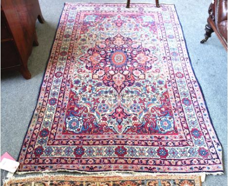 A Kirman Laver rug, Persian, the ivory field with a bold indigo floral pole medallion, madder spandrels, all with floral spra