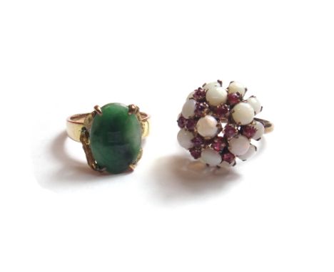 A gold ring mounted with an oval jade between foliate rustic shoulders, ring size 0 and a half, and a gold, ruby and opal set