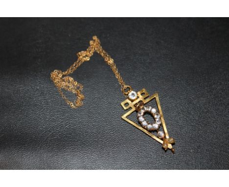 AN UNUSUAL YELLOW METAL PENDANT ON 9CT GOLD CHAIN