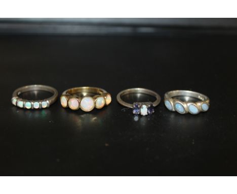 FOUR SILVER DRESS RINGS SET WITH OPAL STYLE STONES