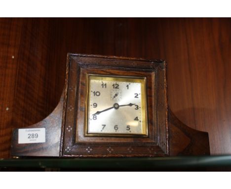 A VINTAGE CARVED OAK MANTLE CLOCK